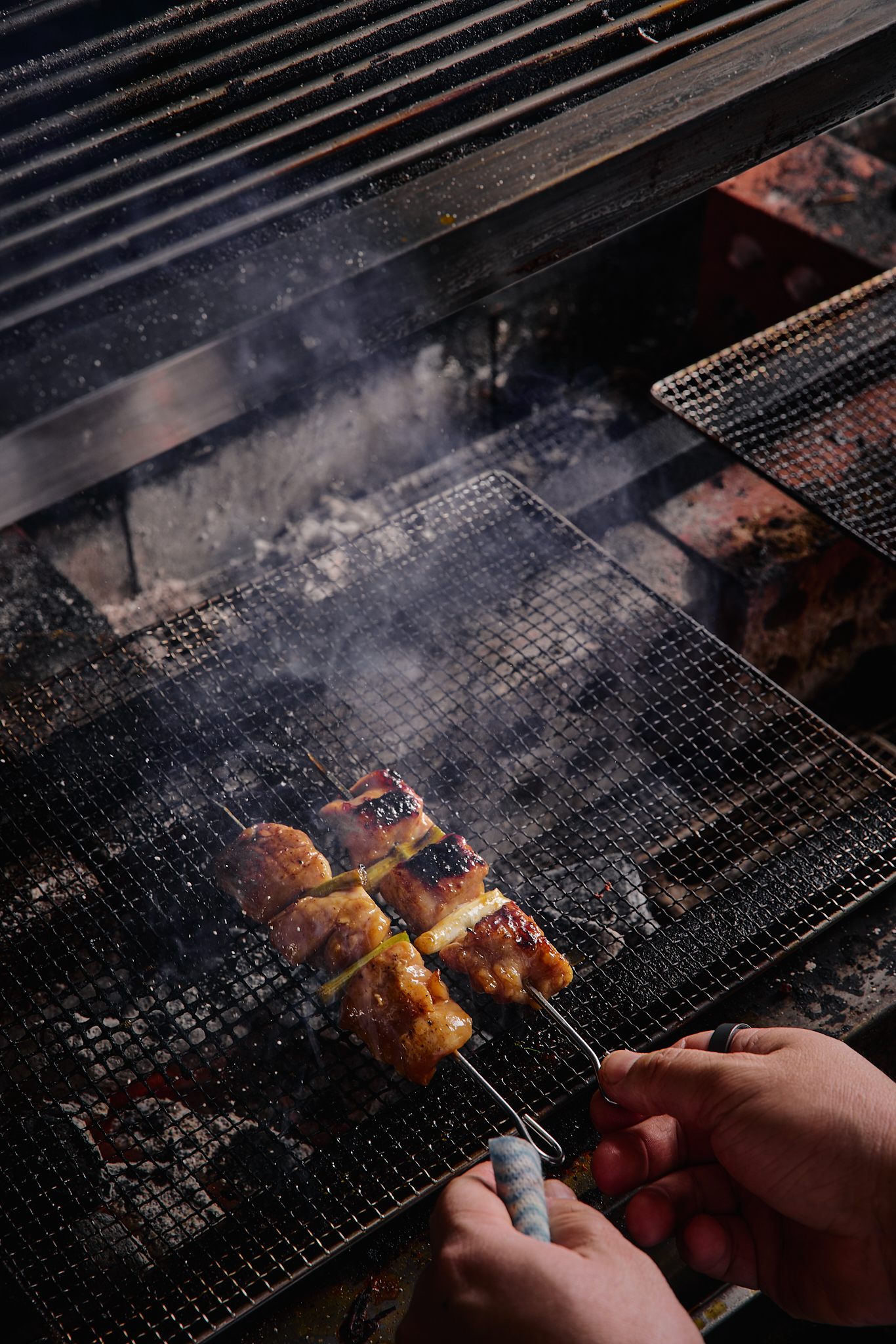 Akaiito chef cooking over charcoal in the open kitchen
